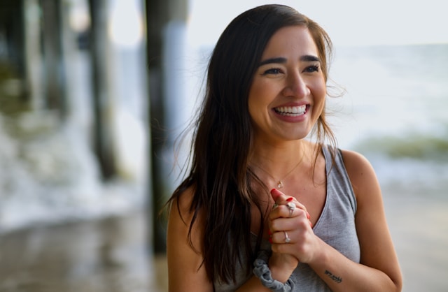 Femme souriante, se tenant les mains pleine de gratitude
